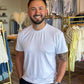 Man standing in a clothing store with racks of clothes in the background